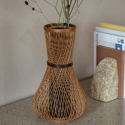 Japansk bambusblomstervase "Fukuju" i brun, placeret på et konsolbord, set i en konsolopstilling.