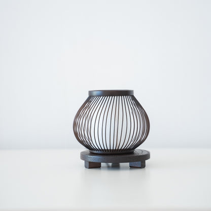 Minimalist bamboo table lamp on a table in a Japandi style bedroom, showcasing 800 years of craftsmanship from Shizuoka, Japan.