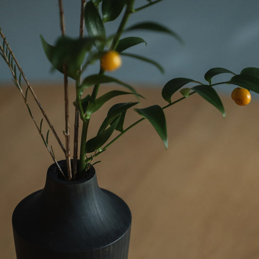Japanse ceder Ikebana-vaas Indigo 02 in marineblauw, gestyled in een eetkamer, zicht op de eettafel.