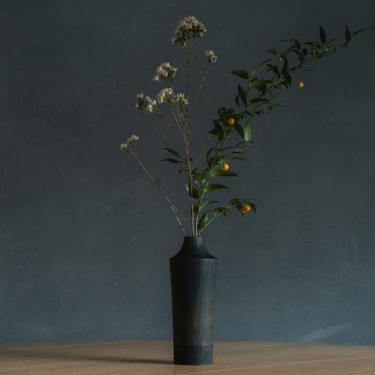 Japanse ceder Ikebana-vaas Indigo 02 in marineblauw, gestyled in een eetkamer, zicht op de eettafel.