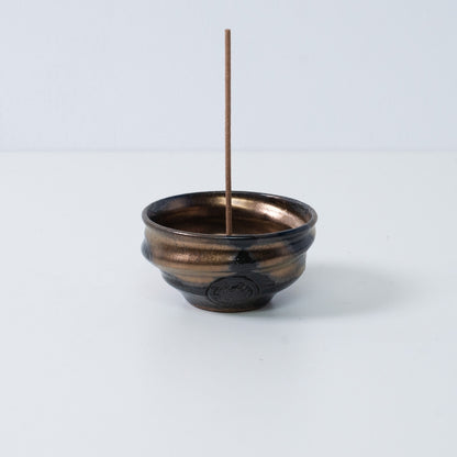 Standalone Japanese incense holder "Zen" pottery bowl with a stick, featuring a gold and black glaze and an artisan seal.