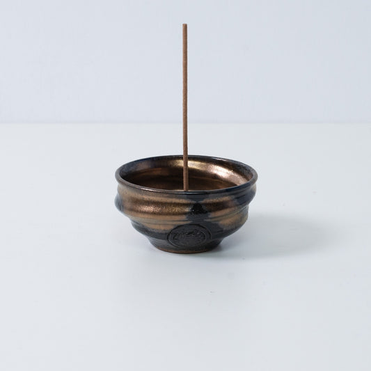Standalone Japanese incense holder "Zen" pottery bowl with a stick, featuring a gold and black glaze and an artisan seal.