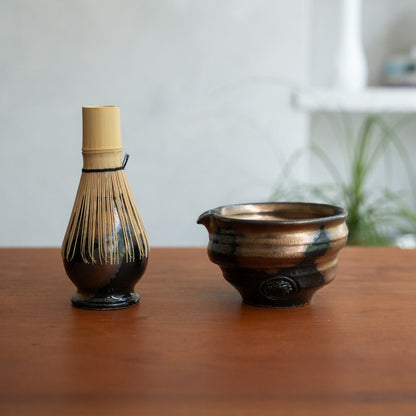 Japanese matcha whisk stand and matcha bowl with spout on a wood table, keeping tools ready for a daily wellness routine.