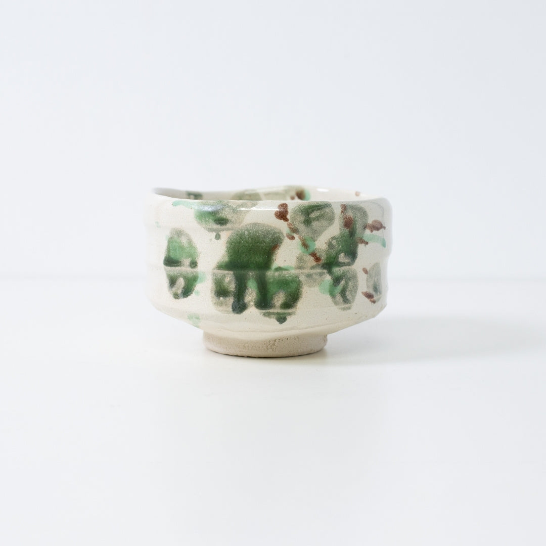 Handcrafted Japanese matcha bowl "Forest" made from rough Shino clay with organic green and brown glaze droplets, created by Shinzan Kiln.