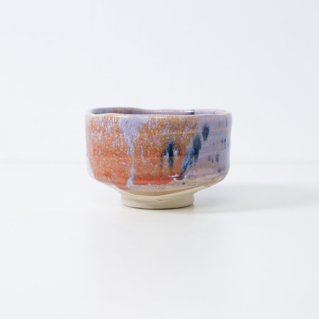 Japanese matcha bowl "Navy & Red Splash" featuring a pale purple Kinyo glaze base with dynamic abstract droplets by Shinzan Kiln.