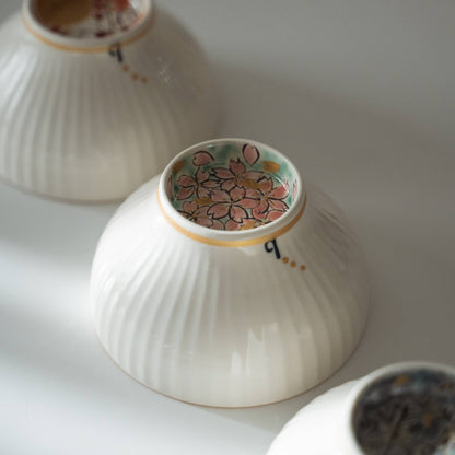 Base of a japanese matcha bowl featuring a hidden sakura flower motif hand painted in gold and pink.