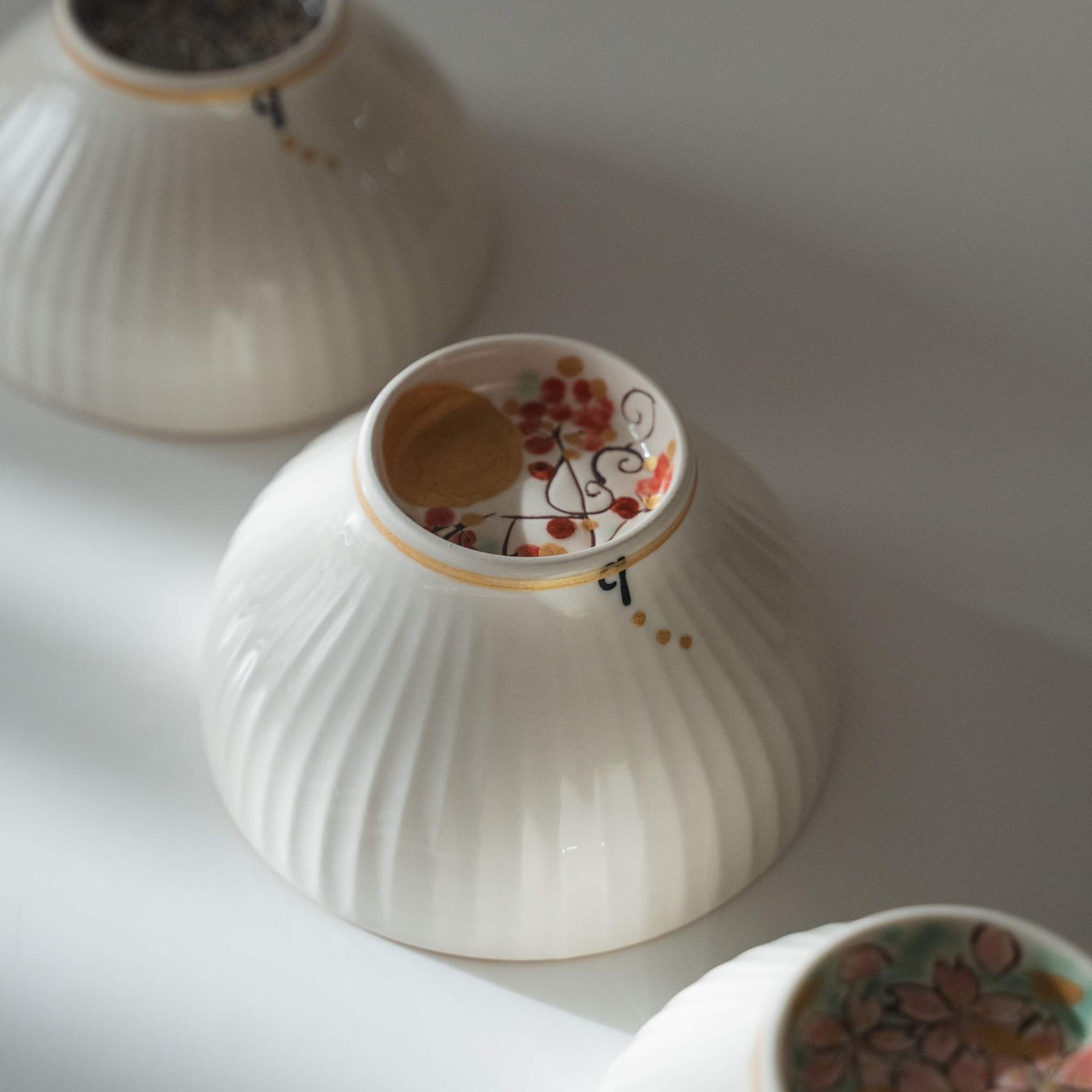 Bottom detail of a japanese matcha bowl with a hidden moon motif painted on the base foot ring.