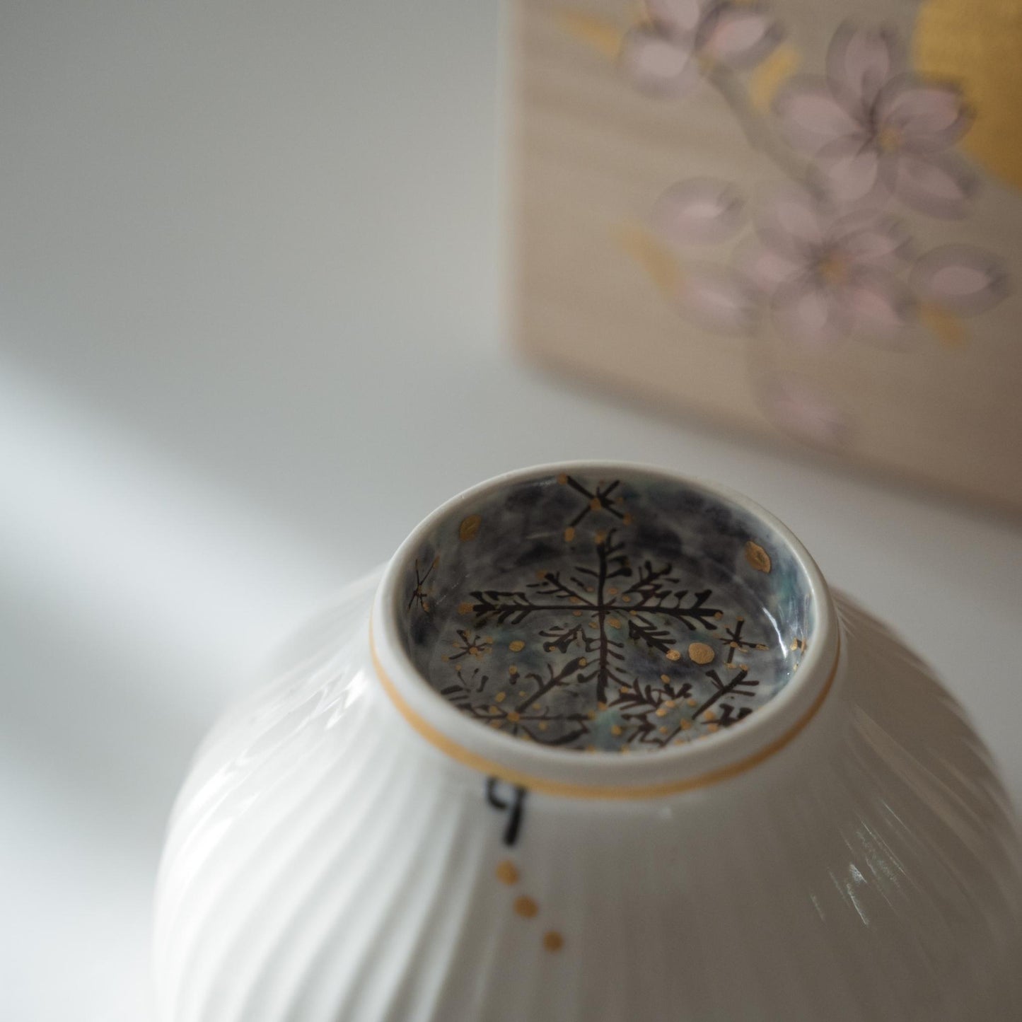 Upside down japanese matcha bowl revealing a blue snowflake design painted inside the base ring.