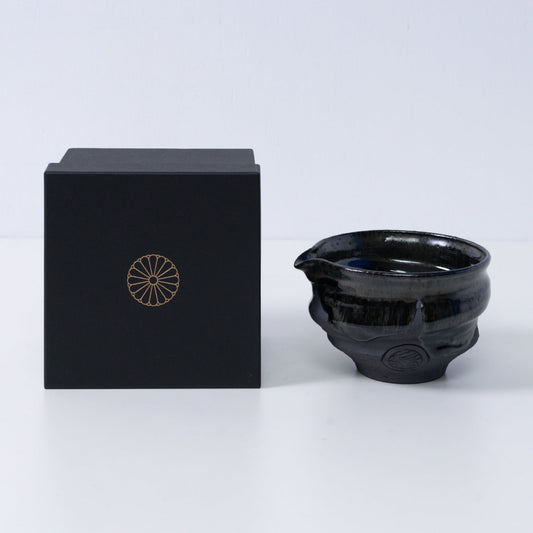 Japanese matcha bowl with spout "Dignity Blue" pottery beside a black gift box with a gold chrysanthemum crest, from Japan.