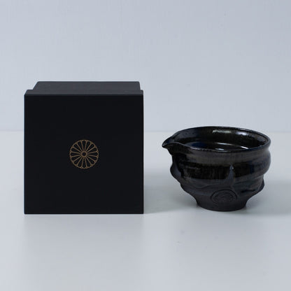 Japanese matcha bowl with spout "Dignity Blue" pottery beside a black gift box with a gold chrysanthemum crest, from Japan.