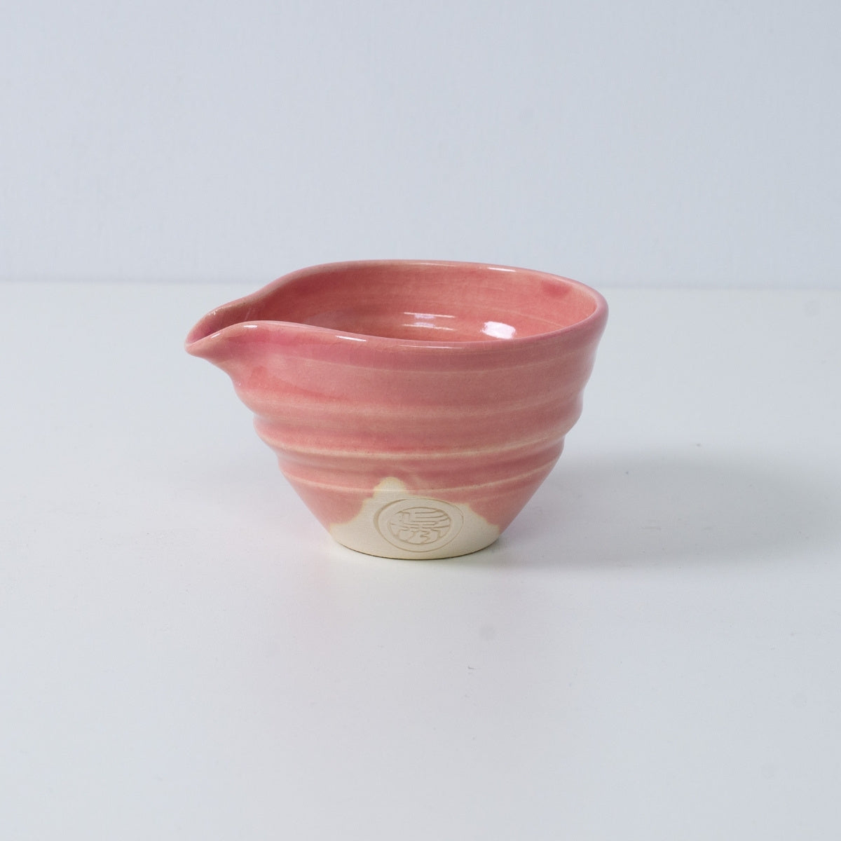 Inside view of a Japanese matcha bowl with spout "Omuro Cherry" pottery, showing the soft pink glaze and swirl pattern, Japan.