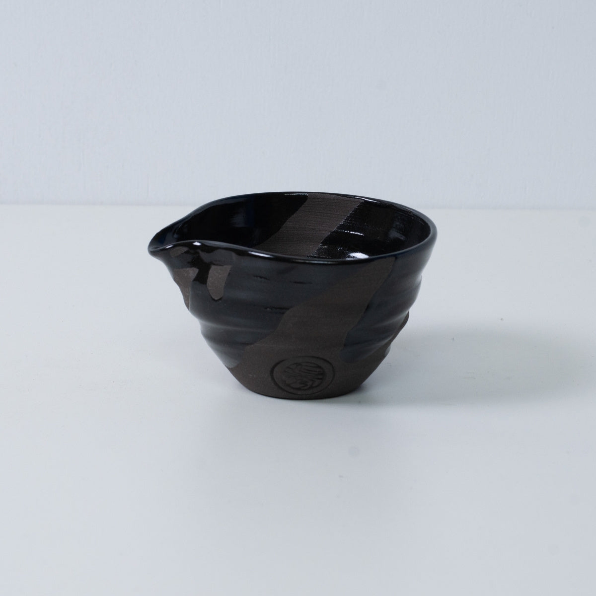 Handcrafted Kyo-yaki pottery Japanese matcha bowl "Sumi Black" with spout and sumi black, featuring an engraved artisan seal, Kyoto ceramics.