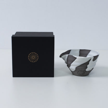 Japanese matcha bowl with spout "White Flow" pottery next to a black gift box with a gold chrysanthemum crest, made in Japan.
