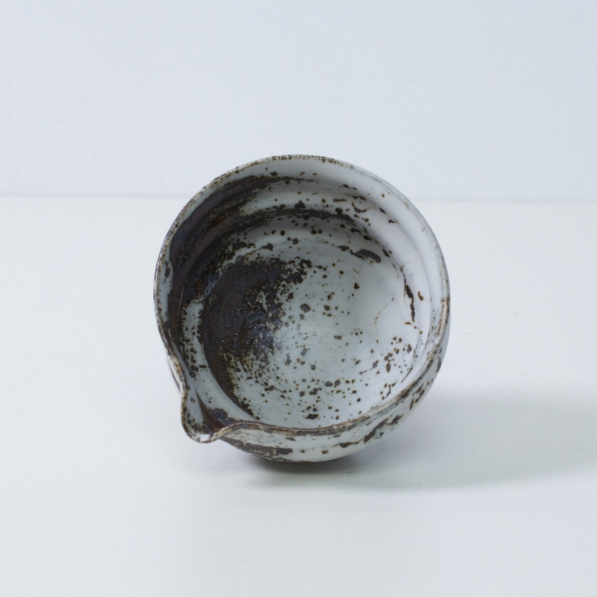Innenansicht einer japanischen Matcha-Schale mit Ausguss, Zui-Keramik, mit ungleichmäßiger weiß-brauner Glasurtextur, hergestellt in Japan.