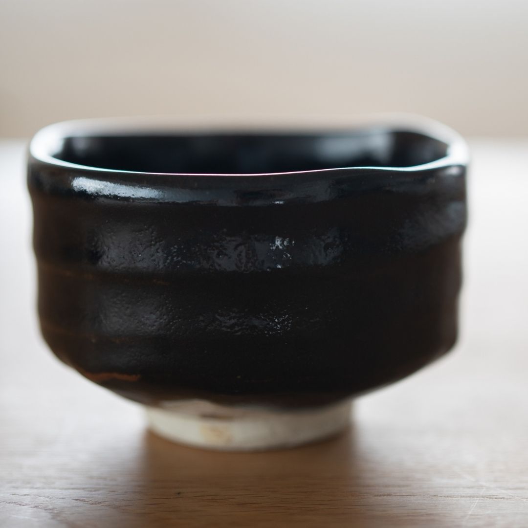 Handcrafted Mino Ware Japanese matcha chawan bowl in Yuzu Black glaze, highlighting the wabi sabi texture.
