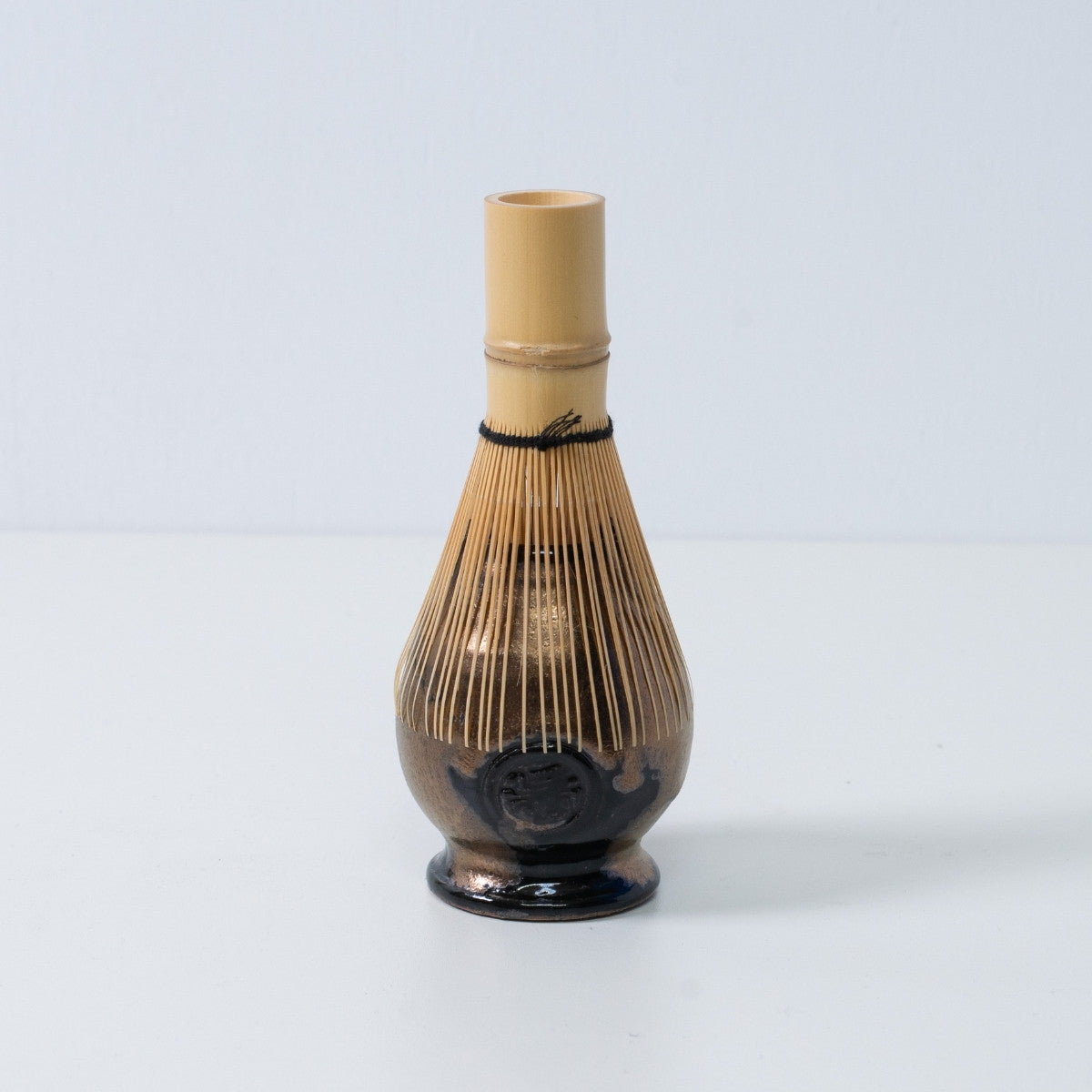 Gold and black Japanese matcha whisk stand "Zen" pottery chasen stand with a bamboo tea whisk placed on top, made in Japan.