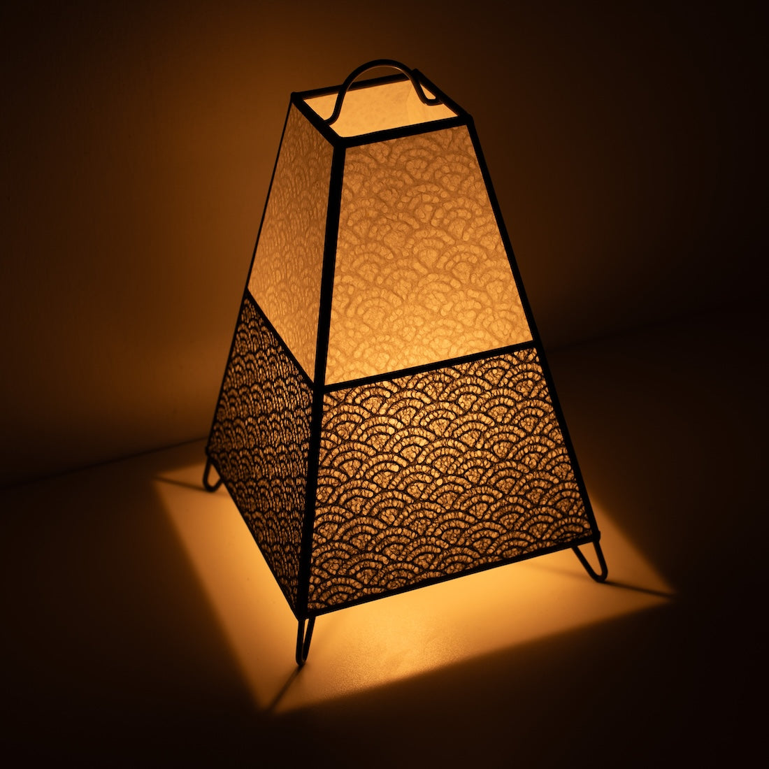 Japanese Paper Floor Lamp KURA Small, monotone, Mino Washi paper - angled view of illuminated paper lamp on wire legs.