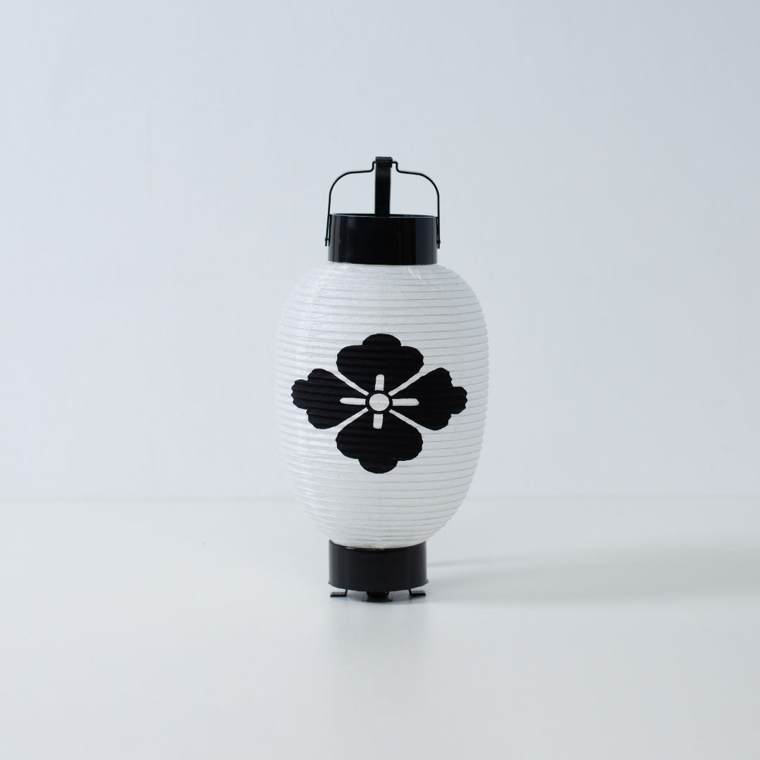 A white Japanese paper lantern featuring a hand-painted black flower diamond hanabishi crest on a white background.