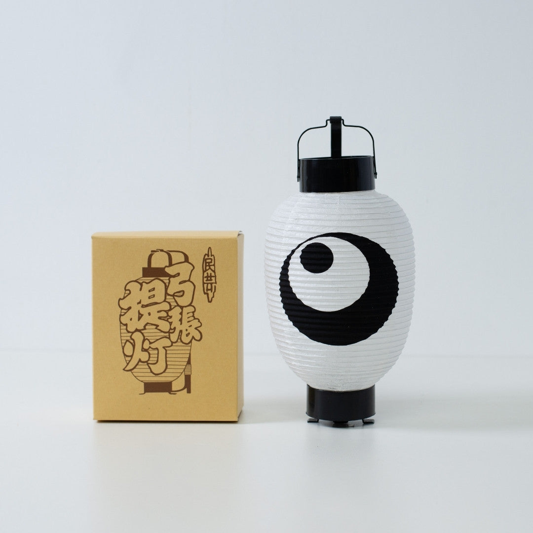 Hand-painted moon and star japanese paper lantern standing next to its traditional kraft paper packaging box.