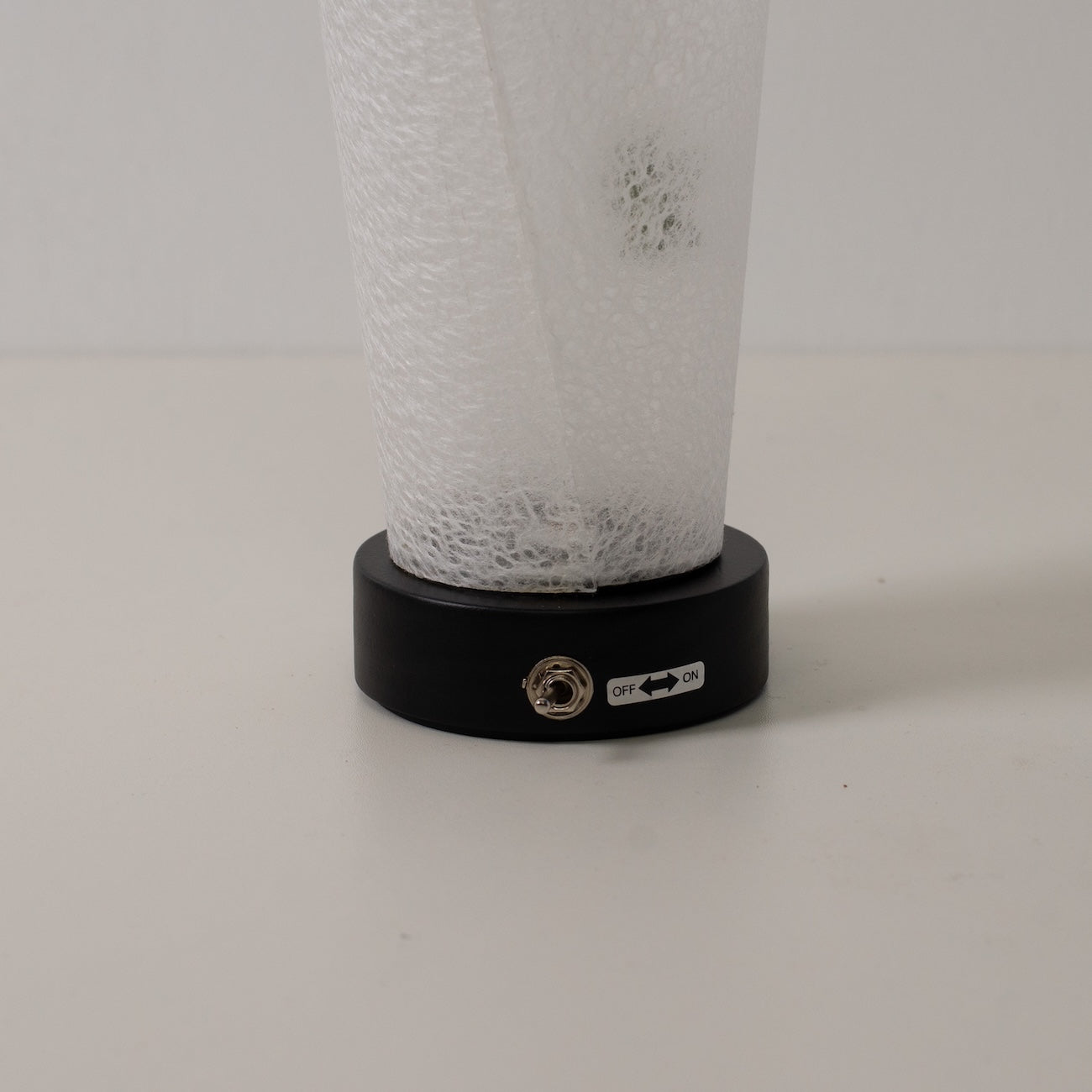 Japanese Paper Table Lamp "Maki" Momiji Leaf, white, wood - close-up of the black base and toggle switch for the cordless lamp.