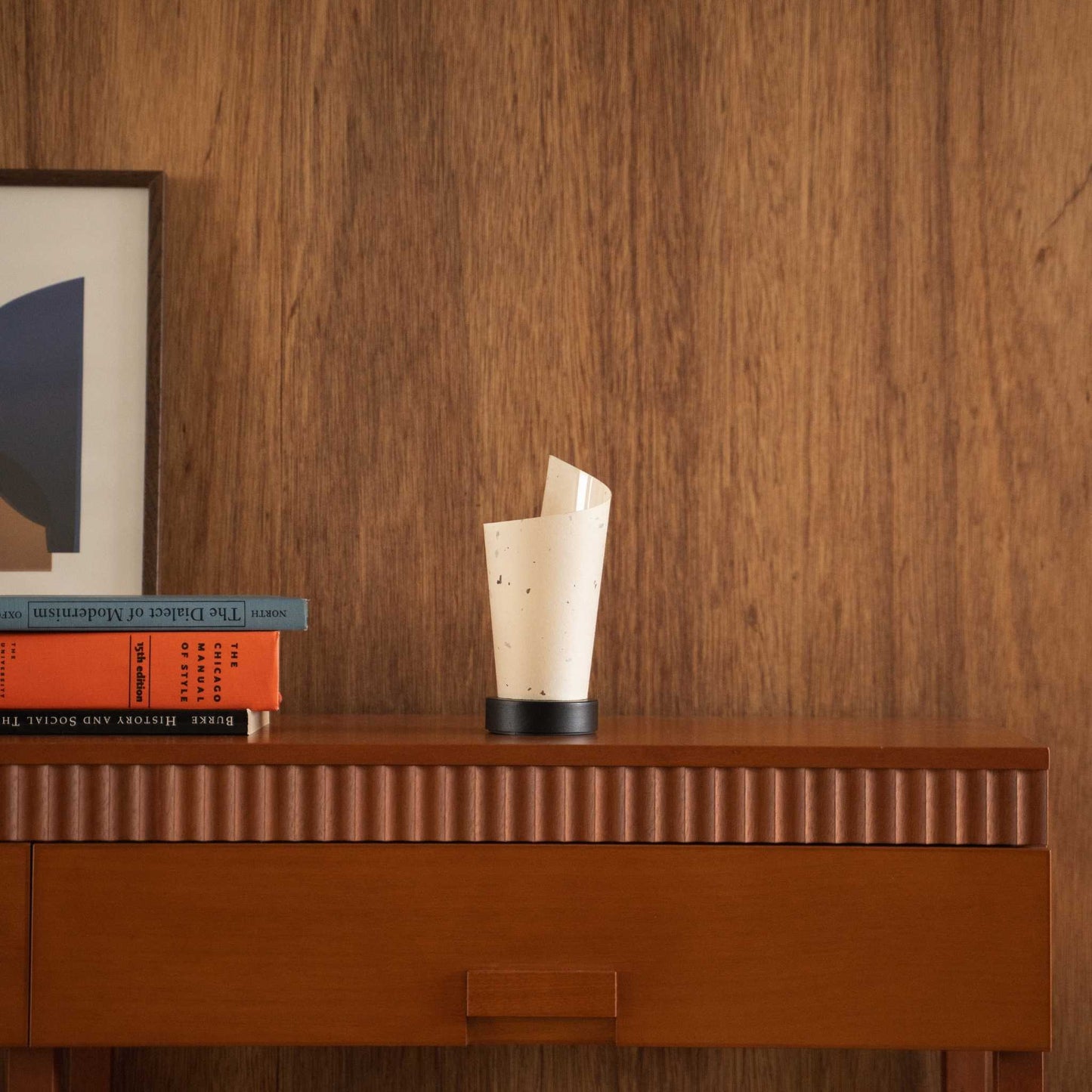 Unlit Japanese paper table lamp "Maki" with a rolled shape styled on a mid-century modern wooden console table.