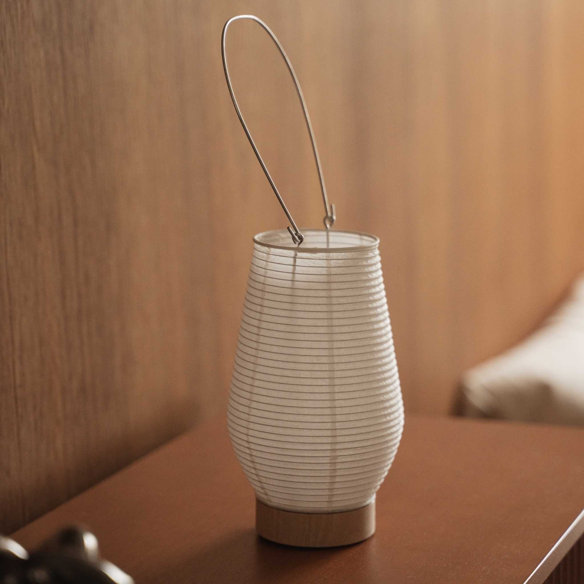 Small japanese paper table lamp Rin 02 sitting on a brown wooden console table showcasing its round white shape