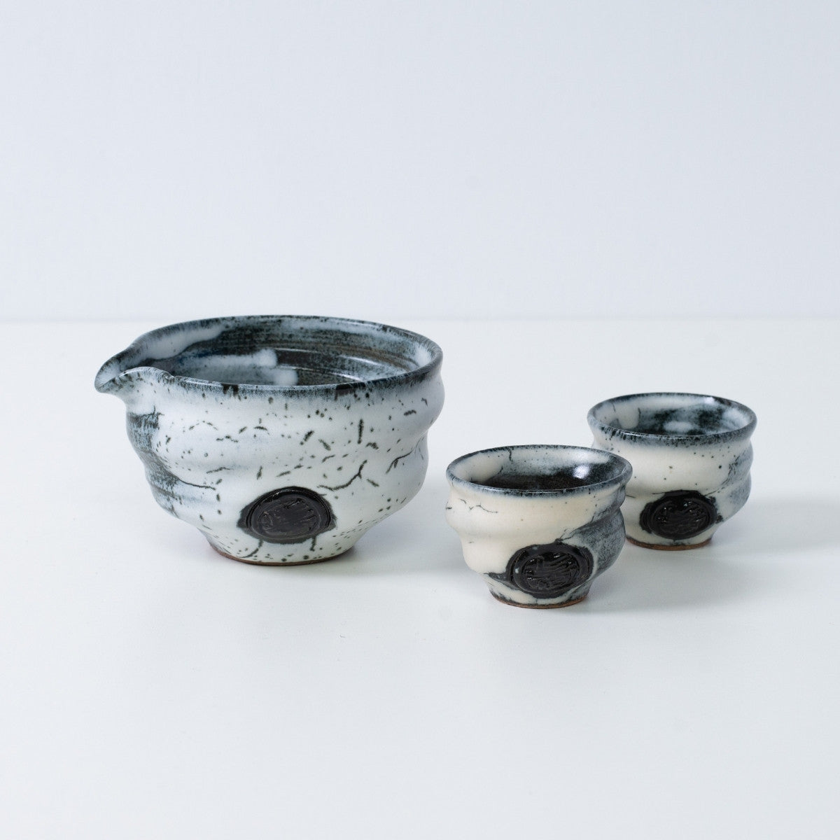 Weißes und schwarzes japanisches Sake-Set "Creative Cloud" aus Keramik mit Katakuchi-Sakekrug und zwei kleinen Sakebechern, hergestellt in Japan.
