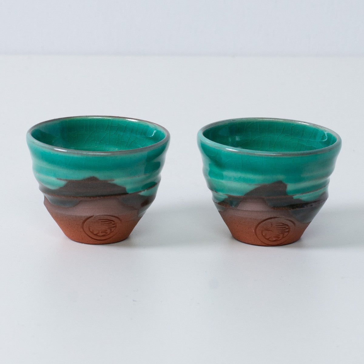 Zwei smaragdgrüne und orangefarbene japanische Sake-Becher Ochoko „Smaragdgrün“ aus Keramik aus Japan, mit rotem Ton und einem eingravierten Siegel des Kunsthandwerkers.