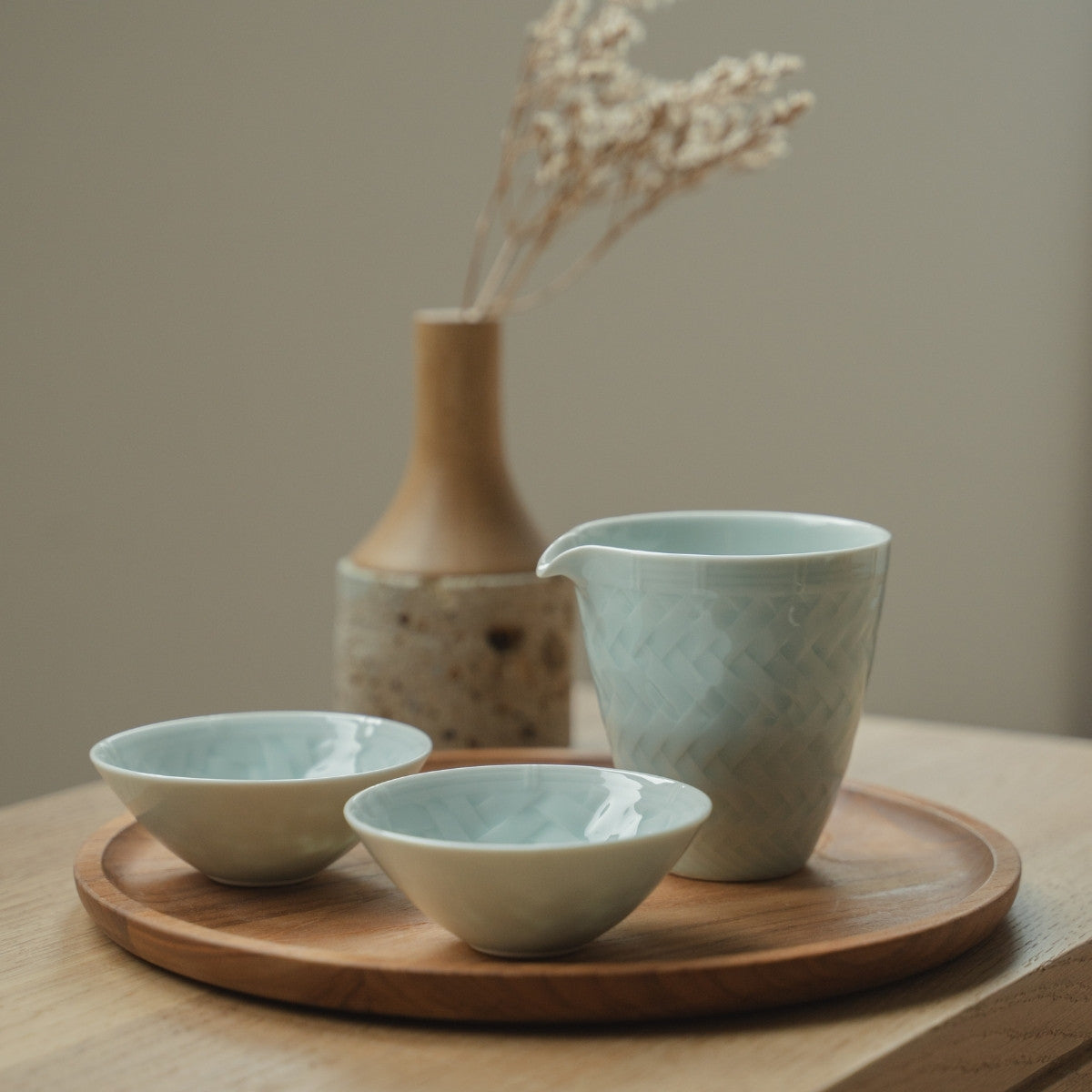 Ice blue arita porcelain sake set from Japan on a wooden tray, set for a mindful modern dining experience.