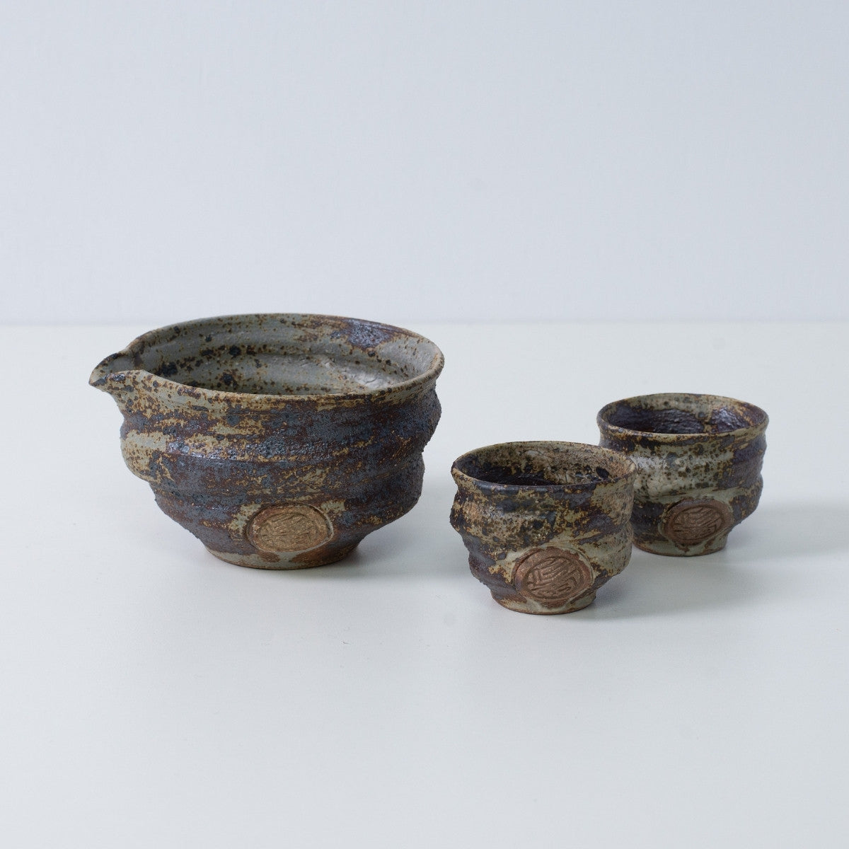 Rustikales braunes japanisches Sake-Set "Sakigake" aus Keramik mit einem Katakuchi-Sakekrug und zwei kleinen Sakebechern, hergestellt in Japan.