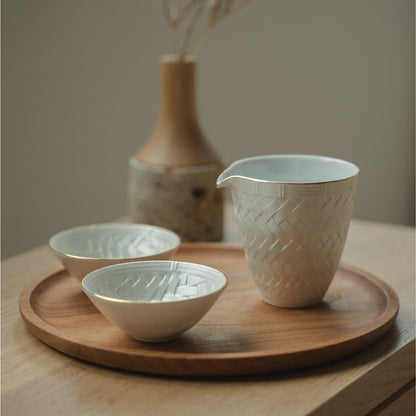White Japanese arita porcelain sake carafe and sake cups from Japan on a wooden tray, set for a mindful dining experience with guests.