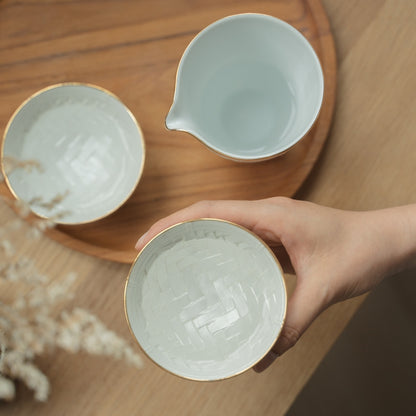 Hand holding a textured white Japanese arita porcelain sake cup over a wooden tray, inviting sake lovers to enjoy a quiet evening.