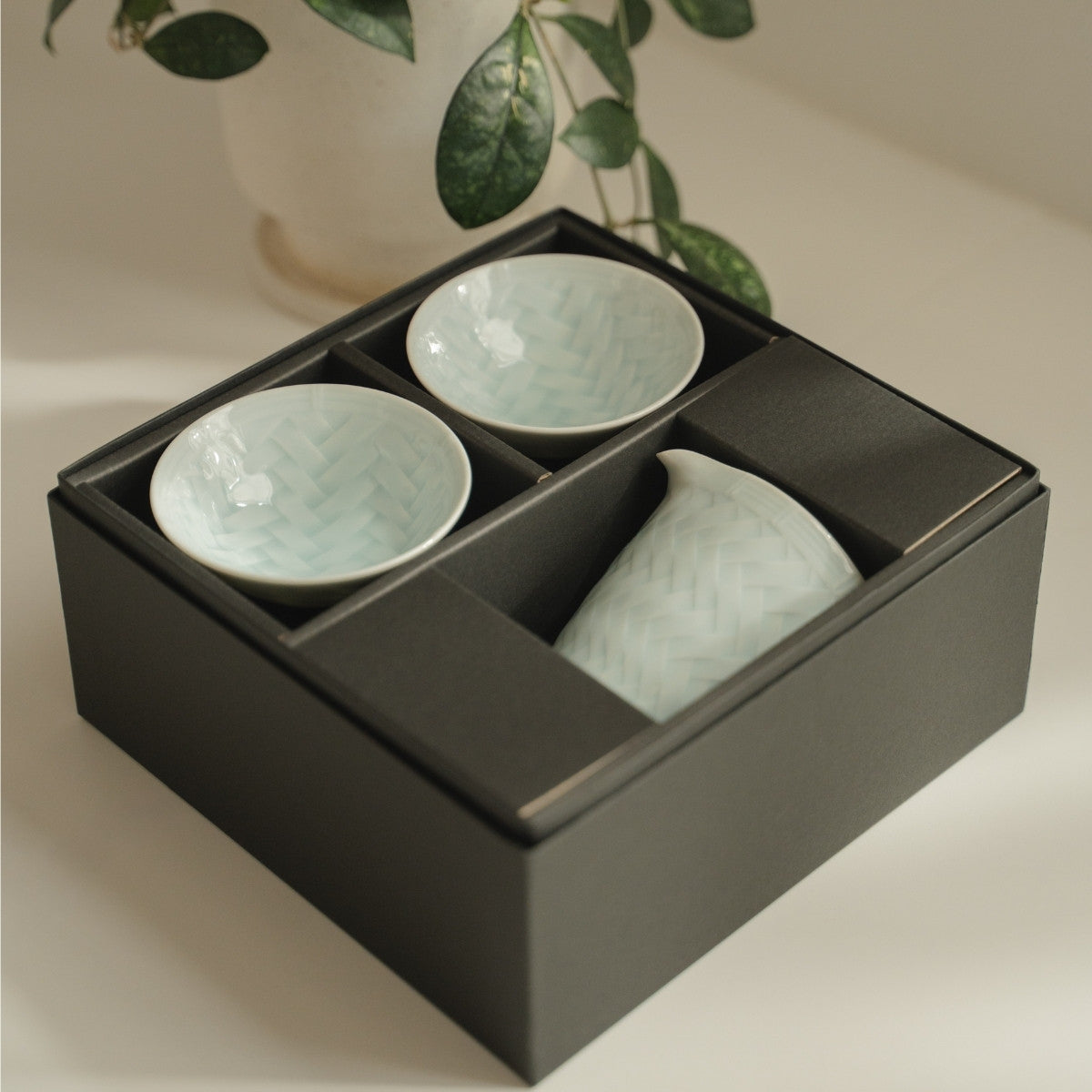 White arita porcelain sake set from Japan in an elegant black gift box on a modern table, ready for sake lovers to gift.