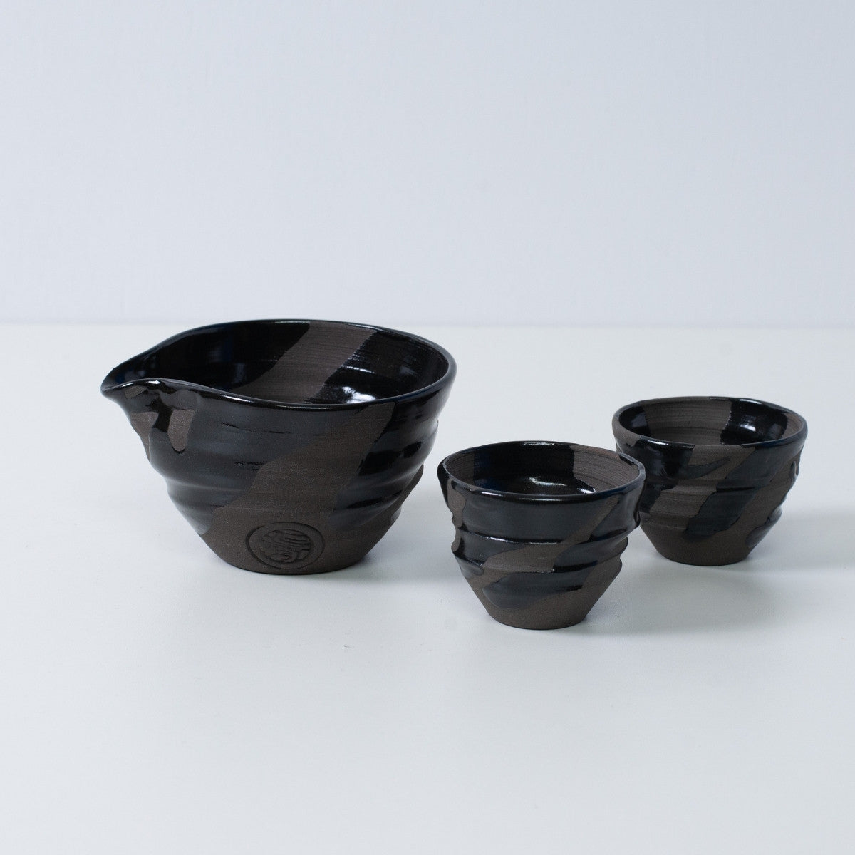 Japanisches Sake-Set "Sumi Black" aus Keramik mit Katakuchi-Sakekrug und zwei kleinen Sakebechern, hergestellt in Japan.
