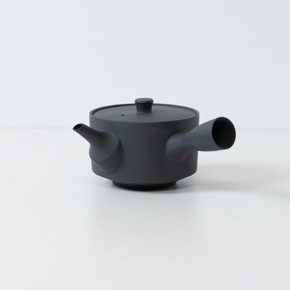 Side view of a black japanese sencha teapot with a side handle and lid on a white background.