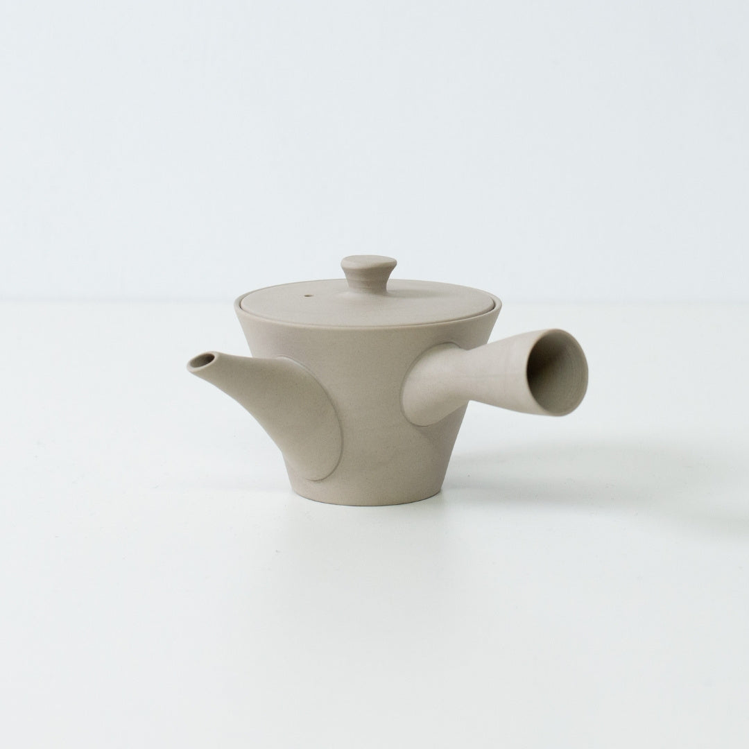 Side view of a white banko yaki japanese teapot with a side handle showing modern minimalist design for sencha brewing.