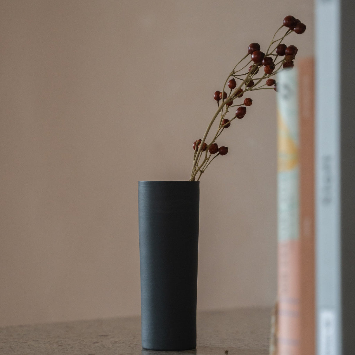 Japanese Single Flower Vase "Cylinder" in black styled in a console table setting, console scene view.