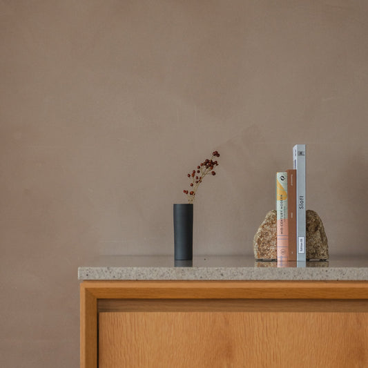 Japanse bloemenvaas "Cylinder" in zwart, gestyled op een sidetable, console-scène.
