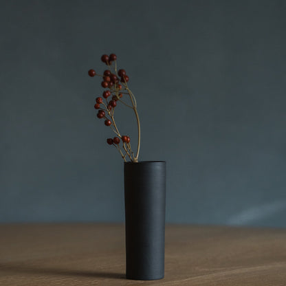 Japanese Single Flower Vase "Cylinder" in black styled in a dining room setting, dining scene view.