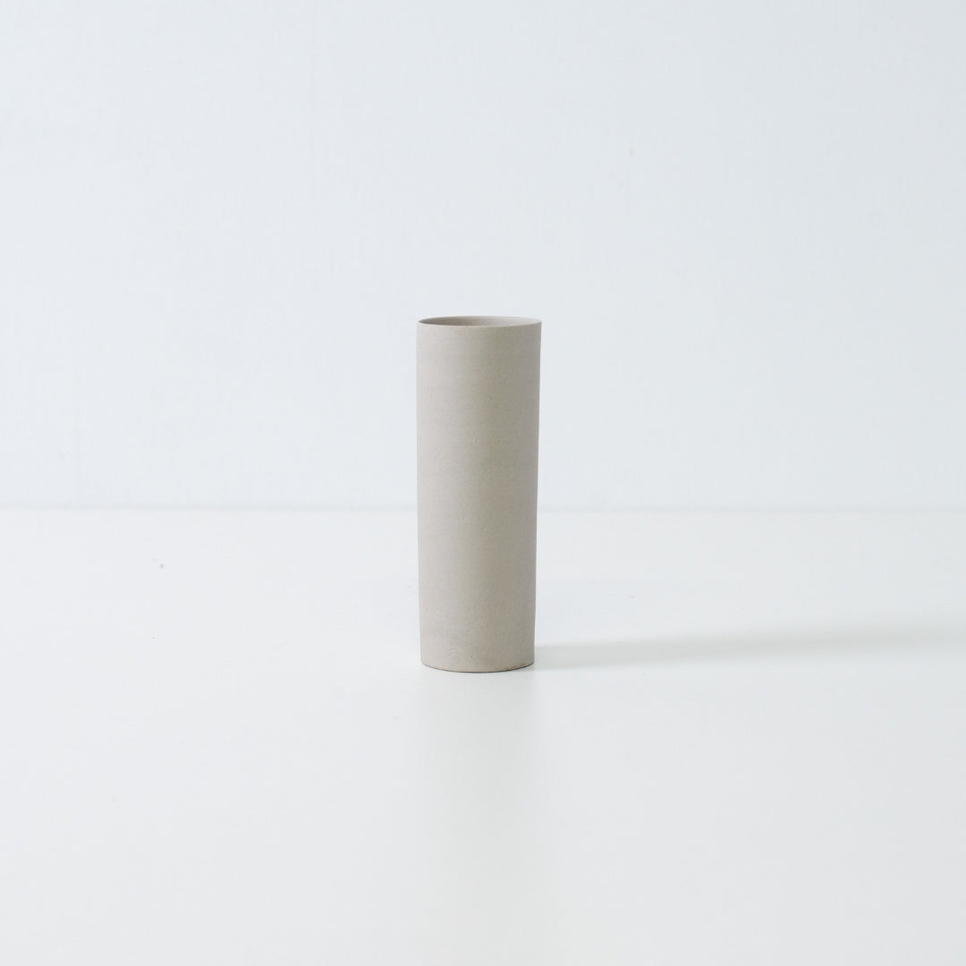 minimalist white Japanese flower vase with a slender cylindrical form handcrafted for seasonal single blooms.