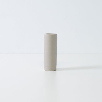minimalist white Japanese flower vase with a slender cylindrical form handcrafted for seasonal single blooms.