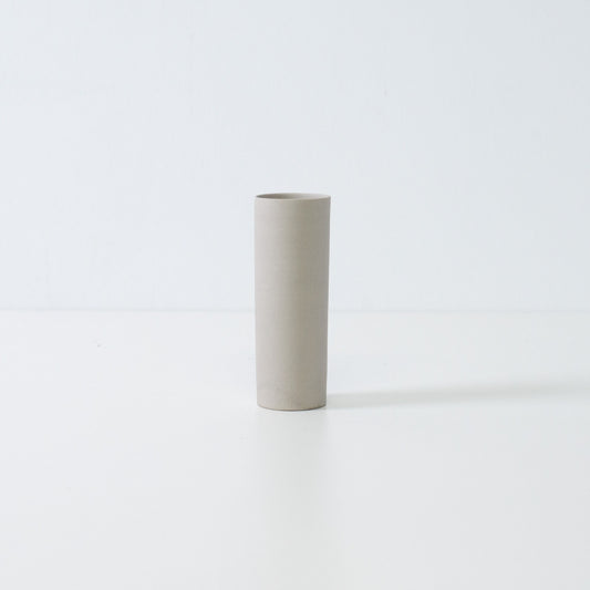 minimalist white Japanese flower vase with a slender cylindrical form handcrafted for seasonal single blooms.
