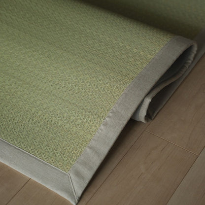 Japanese natural rush tatami area rug folded on a wood floor, offering a smooth texture for minimalist Japanese decor.