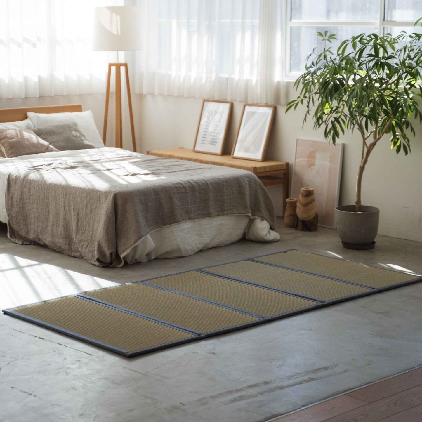 Five panel asanoha tatami mattress laid on a concrete bedroom floor serving as a breathable base for a futon.