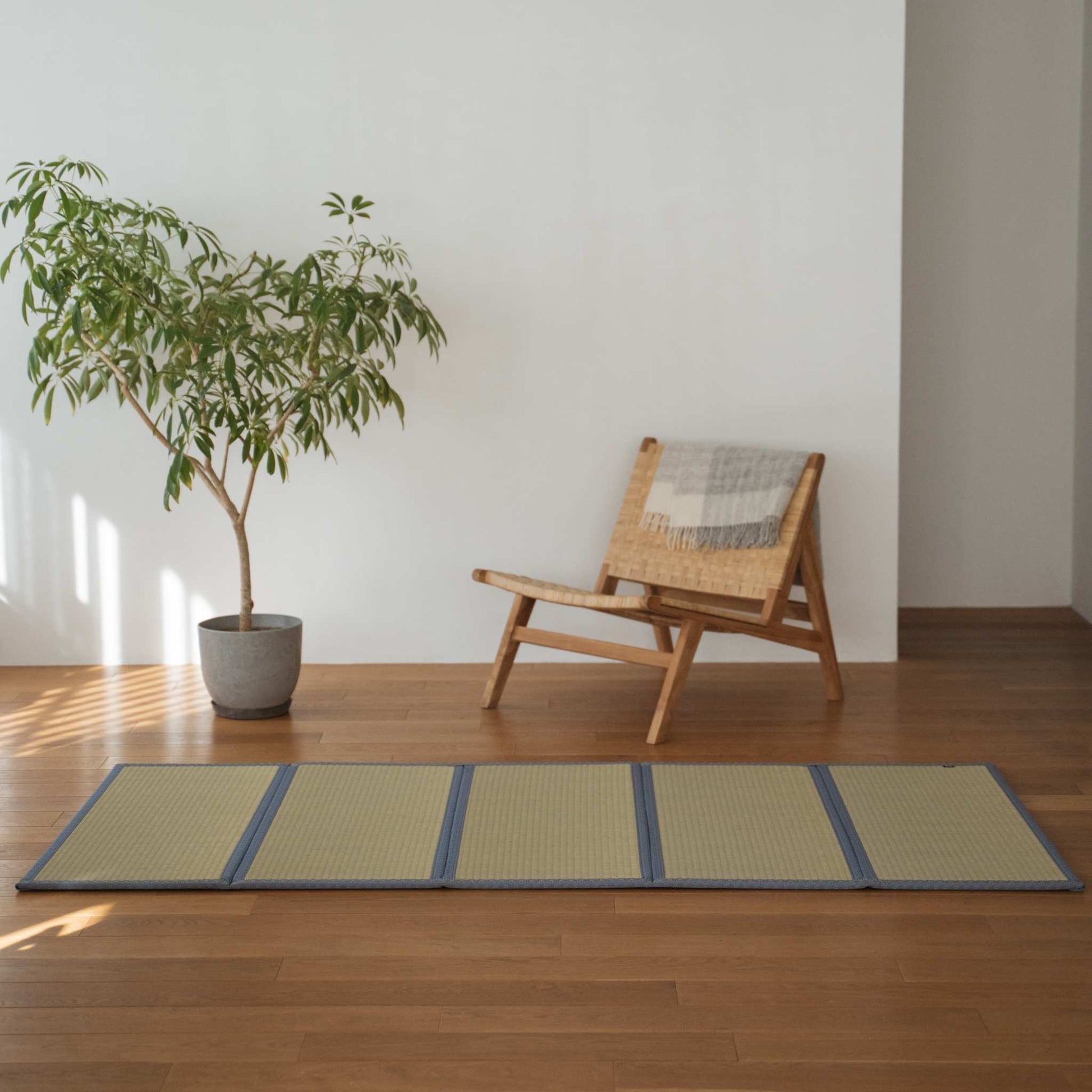 Large five panel tatami mat with hemp leaf pattern placed on a wooden living room floor for zen decor.