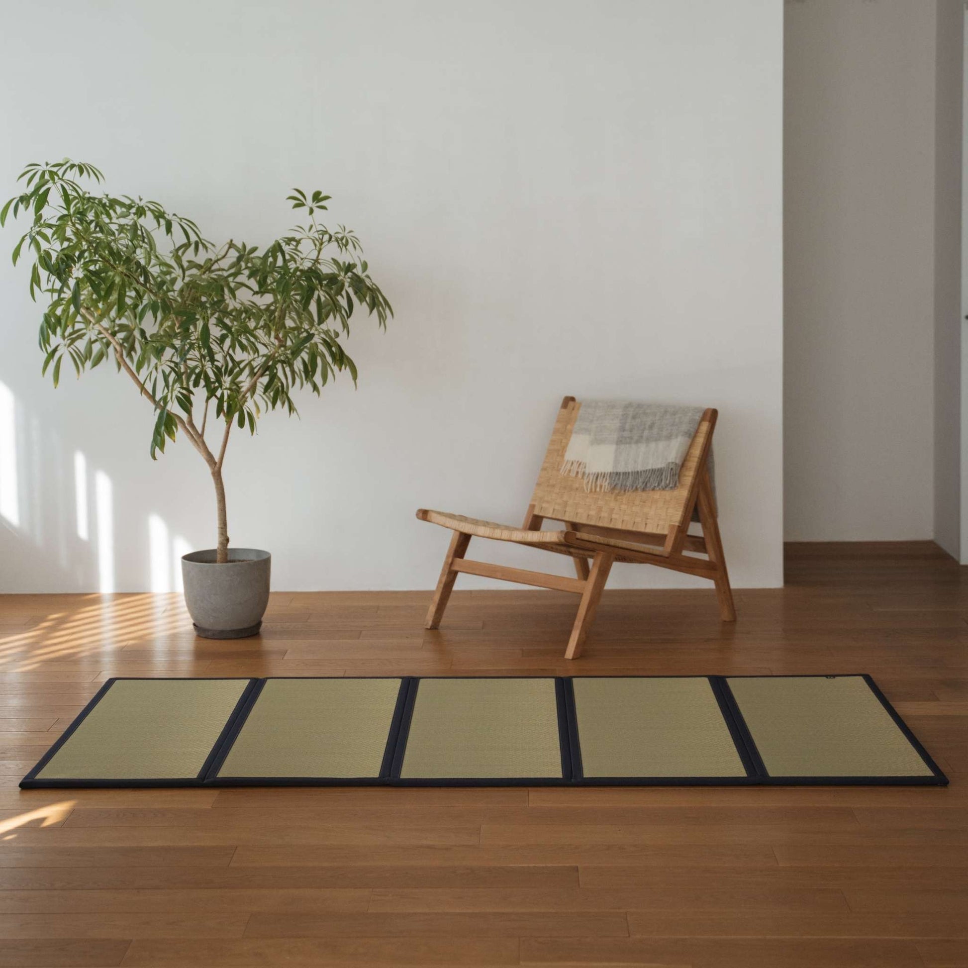 Five panel undyed tatami mat laid on a wooden living room floor offering a smooth and natural zen decor.