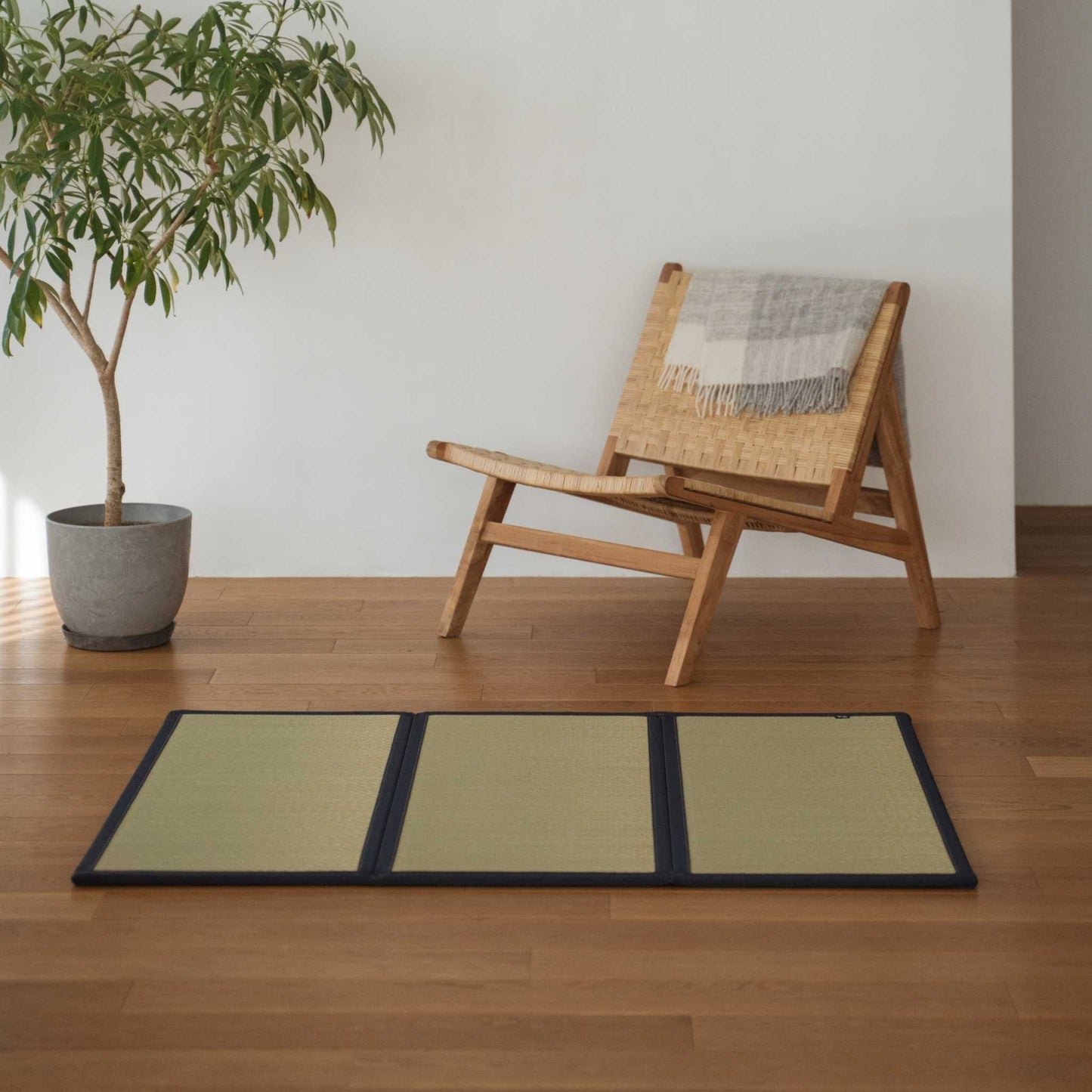 Three panel undyed tatami mat laid on a wooden living room floor offering a smooth and natural zen decor.