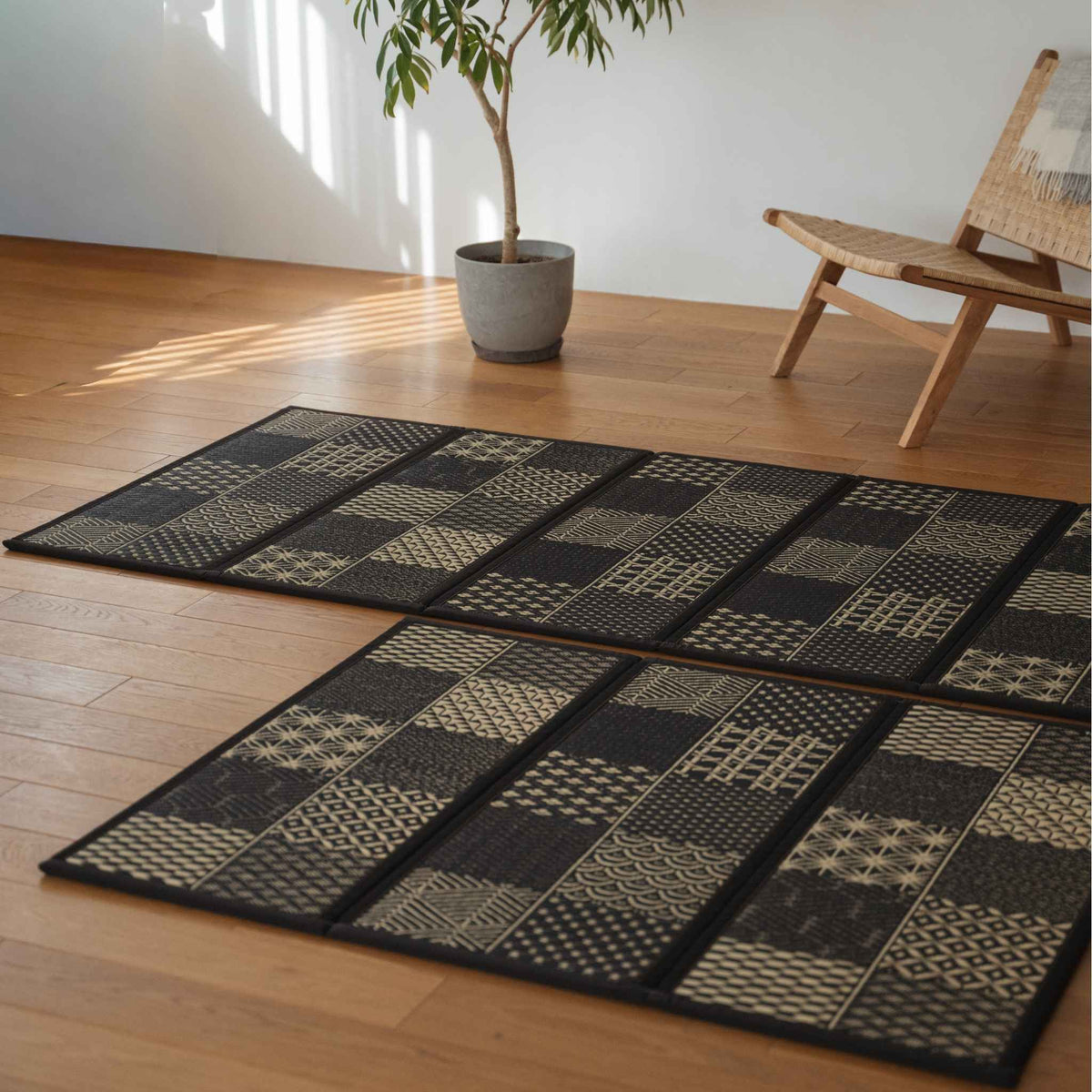 Detailed view of edokomon tatami mat panels on a floor showing unique geometric cuts and black rush grass texture.