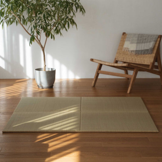 Four square tatami mat panels laid on a wooden living room floor creating a natural zen decor corner.