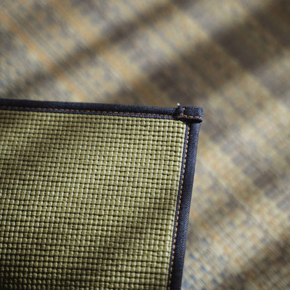 Corner detail of a tatami mat featuring a Kaihara denim hem and non slip PVC backing for yoga.